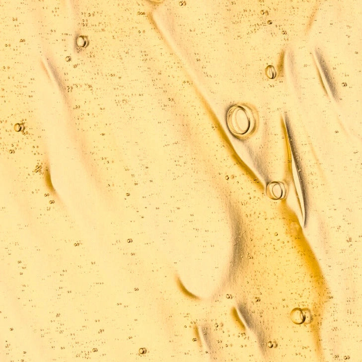 Close-up of a Age-defy
elixir with bubbles on a textured surface
