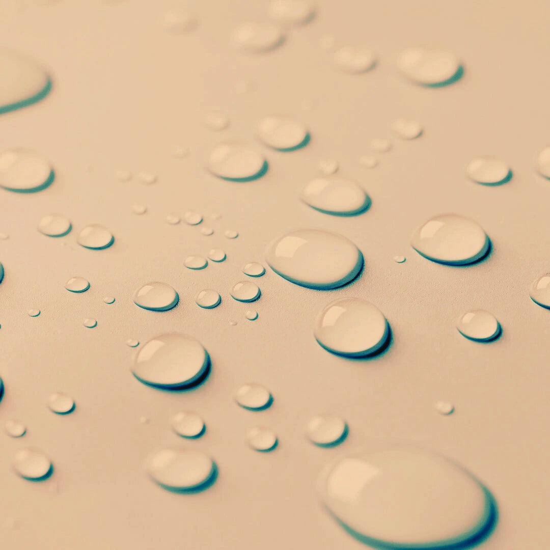 Close-up of water droplets for the Blemish Control Mist on a textured surface