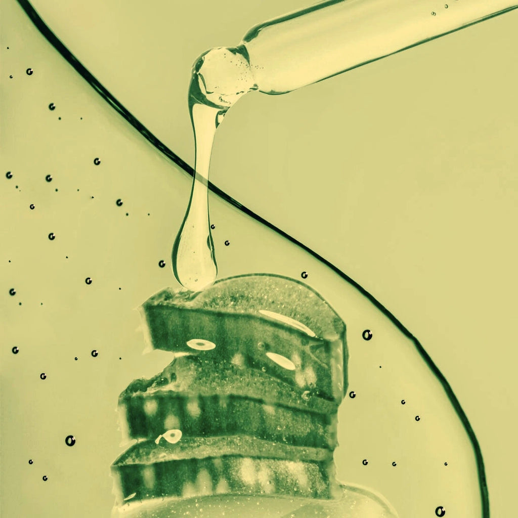 Close-up of a dropper with Blemish Spot Remover on a textured surface.