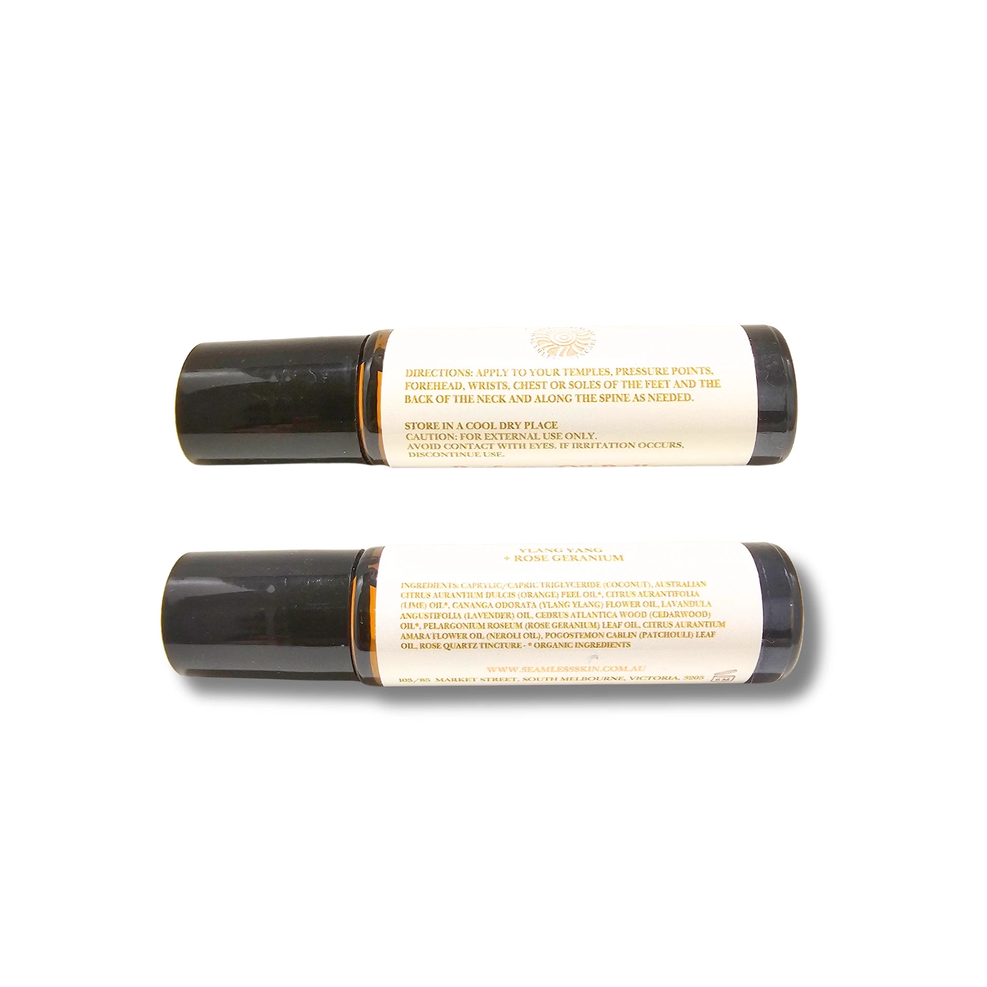 Back of Perfume oil roller with black cap and cream label on a white background